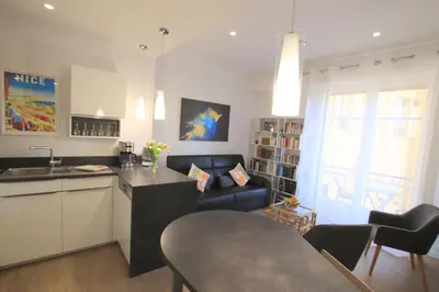 a kitchen and living room with a couch and a table at La Suite Liberation in Nice