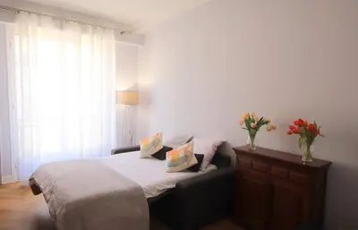 a bedroom with a bed and a dresser with flowers on it at La Suite Liberation in Nice