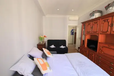 a bedroom with a bed with a dresser and a chair at La Suite Liberation in Nice