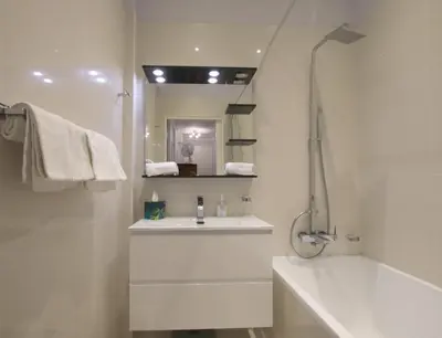 a white bathroom with a sink and a mirror at La Suite Liberation in Nice
