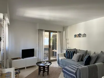 a living room with a couch and a tv at La Petite Ancre in Beaulieu-sur-Mer