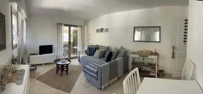 a living room with a couch and a television at La Petite Ancre in Beaulieu-sur-Mer