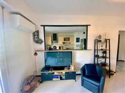 a living room with a blue chair and a large screen tv at Nice Ouest Caucade- Beautiful 2P, AC, Clim in Nice