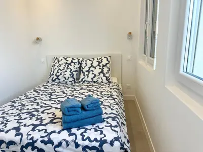 a small bedroom with a bed with blue towels on it at Beautiful & cosy appart, calme et lumineux in Nice