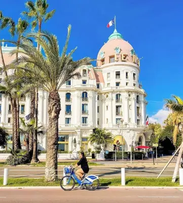 a man riding a bike in front of a building at Beautiful & cosy appart, calme et lumineux in Nice