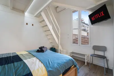 a bedroom with a bed and a stair case at Nice Renting - HONORE - Elegant apartment near Promenade des Anglais in Nice