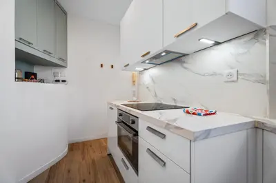 a white kitchen with a sink and a stove at Nice Renting - HONORE - Elegant apartment near Promenade des Anglais in Nice