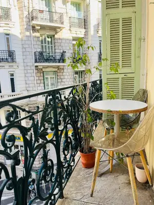 a table and chair on a balcony with a building at Charmant studio en plein coeur de Nice in Nice