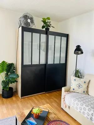 a black sliding door in a living room with a couch at Charmant studio en plein coeur de Nice in Nice