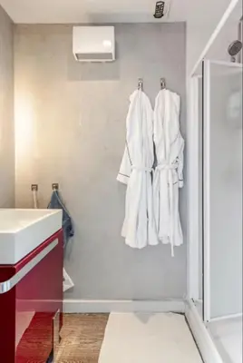 a bathroom with white towels hanging on a wall at French Riviera Escapade - Steps from the Beach in Nice