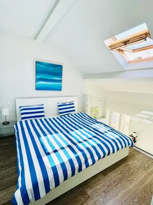 a bedroom with a bed with blue and white stripes at French Riviera Escapade - Steps from the Beach in Nice
