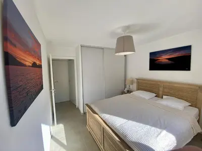 a bedroom with a bed and a painting on the wall at Nice Ouest 2P Sea view, Pool, Quiet in Nice