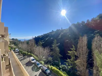 a view of a mountain with cars parked in a parking lot at Nice Ouest 2P Sea view, Pool, Quiet in Nice