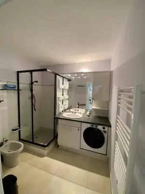 a bathroom with a sink and a washing machine at Nice Ouest 2P Sea view, Pool, Quiet in Nice