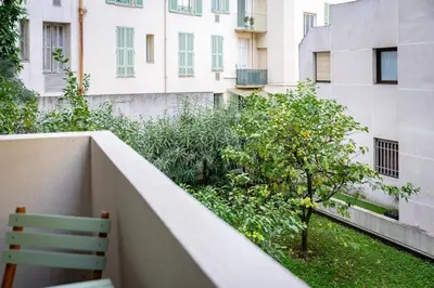 a balcony with a bench and a tree in front of a building at Rivoli- Quiet apartment, close to Negresco in Nice