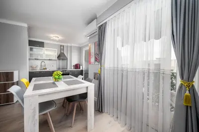 a kitchen and dining room with a white table and chairs at Cozy Appartement close to Port of Nice in Nice