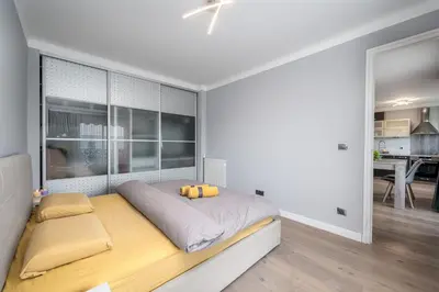a white bedroom with a large bed with yellow pillows at Cozy Appartement close to Port of Nice in Nice