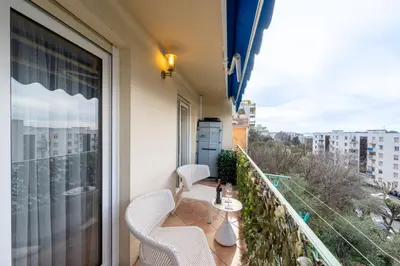 a balcony with two chairs and a table and a window at Cozy Appartement close to Port of Nice in Nice