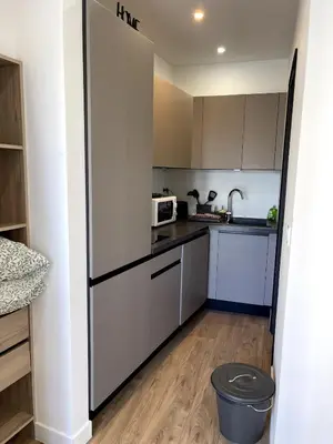 a kitchen with white cabinets and a refrigerator at Joli Studio Place Garibaldi, Vieux-Nice, Port in Nice