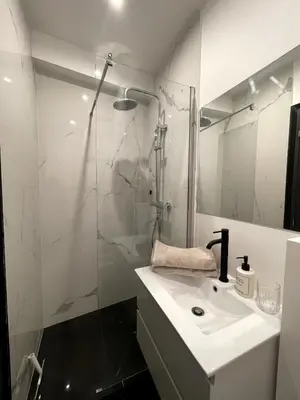 a white bathroom with a shower and a sink at Joli Studio Place Garibaldi, Vieux-Nice, Port in Nice