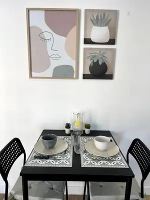a dining room table with two chairs and paintings at Joli Studio Place Garibaldi, Vieux-Nice, Port in Nice