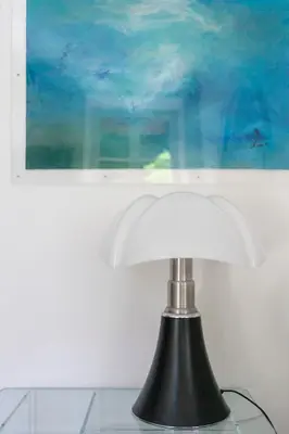 a black and white lamp sitting on a table with a painting at Carré d'Or, superbe apartment sur jardin, élégant et ensoleillé in Nice
