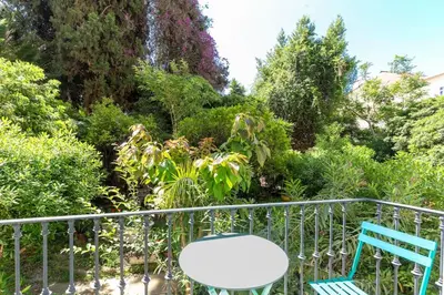 a balcony with two chairs and a table at Carré d'Or, superbe apartment sur jardin, élégant et ensoleillé in Nice