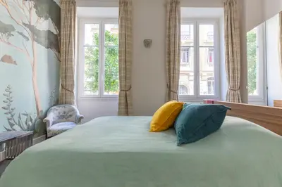 a bedroom with a bed with two pillows on it at Carré d'Or, superbe apartment sur jardin, élégant et ensoleillé in Nice