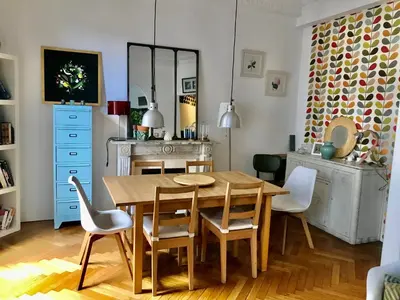 a dining room with a wooden table and chairs at Beau 3 pièces Libération Nice in Nice