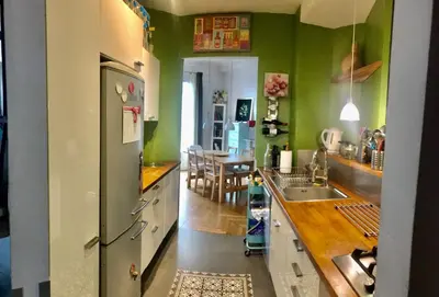 a kitchen with green walls and a dining room at Beau 3 pièces Libération Nice in Nice