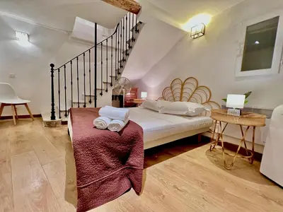 a bedroom with a large bed and a staircase at ApartHotel Riviera - La Maison De Francois - Old Town in Nice