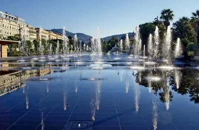 a fountain in the middle of a city with buildings at Pleasant central apartment with balcony in Nice