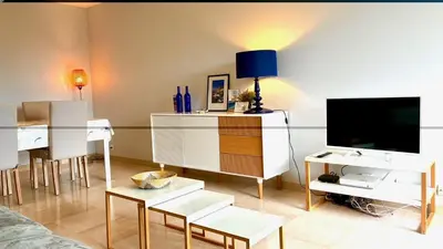 a living room with a tv and a table with chairs at ApartHotel Riviera - Terrasse Felix Faure 2 - Massena in Nice