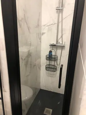 a bathroom with a glass shower door with a toilet at Lovely cozy studio in Nice