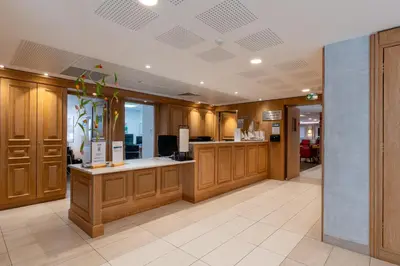 a lobby with wooden cabinets and a cash register at Quality Aparthotel Nice in Nice