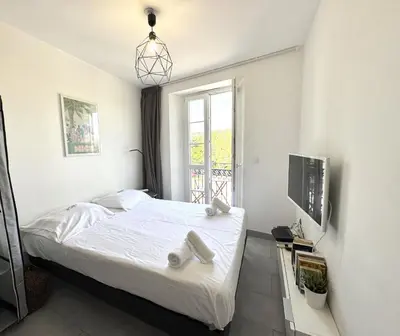 a white bedroom with a bed and a window at ApartHotel riviera - Balcon Jean Jaures 2 - Place Massena - Old in Nice