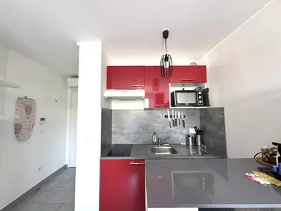 a kitchen with red cabinets and a sink at ApartHotel riviera - Balcon Jean Jaures 2 - Place Massena - Old in Nice