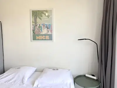a bedroom with a bed and a picture on the wall at ApartHotel riviera - Balcon Jean Jaures 2 - Place Massena - Old in Nice