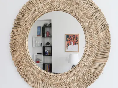 a rattan mirror with a wicker frame in a living room at Apartment Le Palais du Vieux Port by Interhome in Nice
