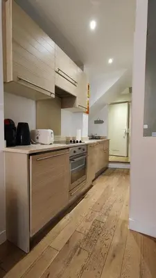 a kitchen with wooden cabinets and a stove top oven at Beach Proximity in Historic Nice, Your Perfect 2 Room Rental in Nice