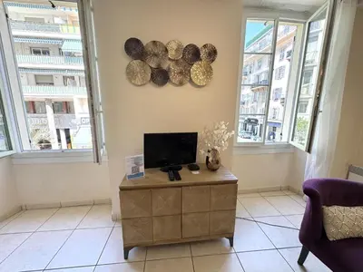 a living room with a tv and two windows at ApartHotel Riviera - Hotel des Postes 2 - City center Massena in Nice