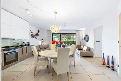 a kitchen and dining room with a table and chairs at Appartement de la Colline - Welkeys in Nice