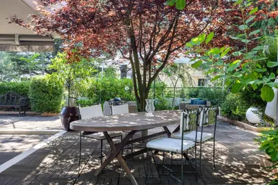 a wooden table and chairs in a garden at Appartement de la Colline - Welkeys in Nice