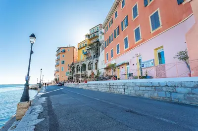 an empty street with buildings next to the water at MARINE AP4445 By Riviera Holiday Homes in Villefranche-sur-Mer