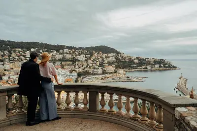 a couple standing on a balcony looking at the city at Azur BnB in Nice