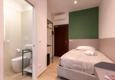a bedroom with a bed and a toilet and a green wall at Azur BnB in Nice