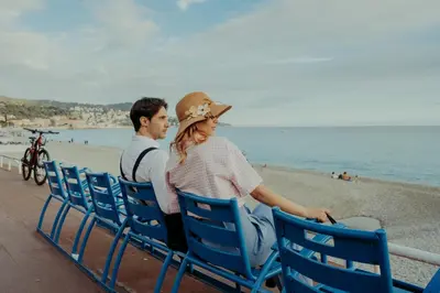 a man and a woman sitting on chairs at the beach at Azur BnB in Nice