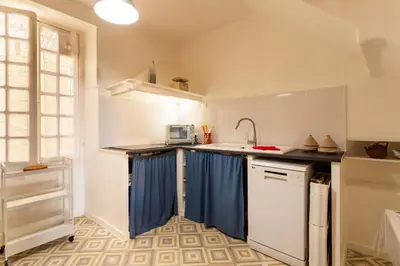 a kitchen with a sink and blue curtains in it at ESCALINADA II AP4433 by Riviera Holiday Homes in Villefranche-sur-Mer