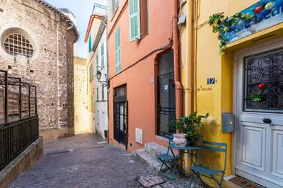 an alley in an old building with a table and chairs at ESCALINADA II AP4433 by Riviera Holiday Homes in Villefranche-sur-Mer