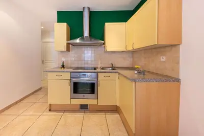 a kitchen with yellow cabinets and a stove at Joli cocon à 3 min à pied de la mer in Nice